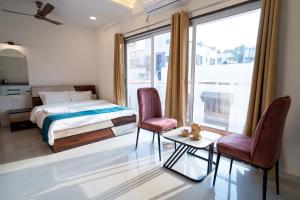 a bedroom with a bed and two chairs and a window at 46 Elite Enclave in Nashik