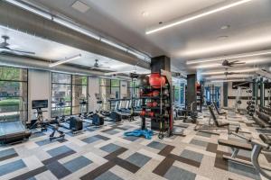 a gym with a lot of treadmills and weights at King Aqua Suite Walkable Legacy West King Bed, Pool & Gym in Plano