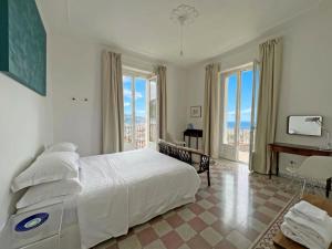 a bedroom with a large bed and large windows at Villa Ipomea - Cielo Suite in Salerno