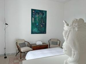 a bedroom with a bed and a painting on the wall at Villa Ipomea - Cielo Suite in Salerno