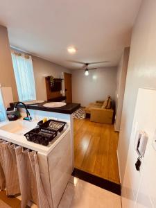 a kitchen with a stove and a living room at Apt 404 BL 6 entrada de londrina in Cambé