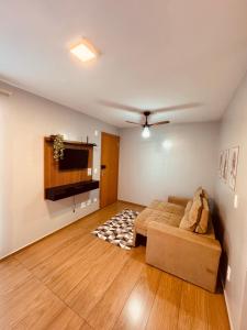 a living room with a couch and a television at Apt 404 BL 6 entrada de londrina in Cambé