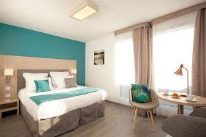 ein Hotelzimmer mit einem Bett, einem Schreibtisch und einem Stuhl in der Unterkunft Residhome Asnieres Park in Asnières-sur-Seine