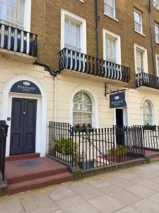 a building with a black door and a balcony at Hotel Meridiana in London