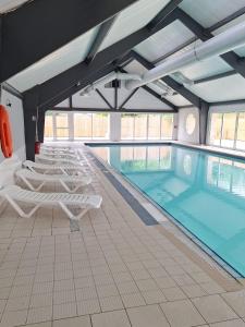 a pool with lounge chairs and a swimming pool at Studio 09 in Sulniac