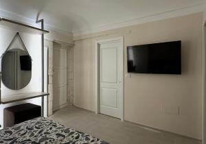 a bedroom with a flat screen tv on a wall at Romantico bilocale ad Ortigia in Syracuse