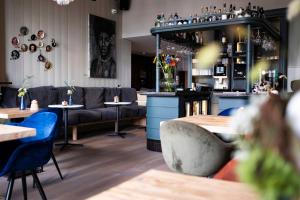 a restaurant with tables and couches and a bar at Logementen Dokkum in Dokkum