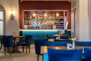 a restaurant with blue chairs and a bar at Colwall Park - Hotel, Bar & Restaurant in Great Malvern