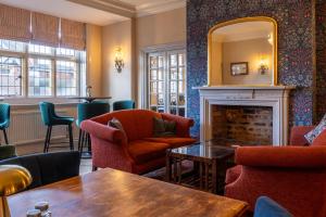 a bar with chairs and a fireplace and a mirror at Colwall Park - Hotel, Bar & Restaurant in Great Malvern