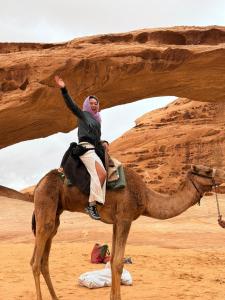 a woman riding on a camel in the desert at Leen Luxury Camp in Disah
