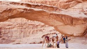 a group of people riding camels in the desert at Leen Luxury Camp in Disah