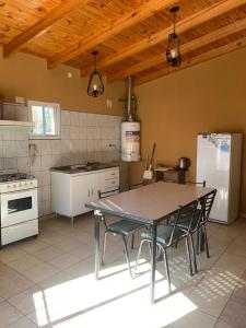 a kitchen with a table and chairs in a room at Apart Cerezos in Los Antiguos