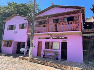 a pink house with a balcony on top at Aconchego do céu in Conceição da Ibitipoca