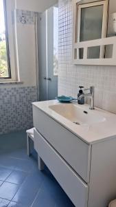 a white bathroom with a sink and a mirror at Villa Bella Vista in Zambrone +15 photos