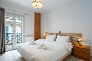 a bedroom with a large white bed and a window at Galaxy Rooms in Paralio Astros