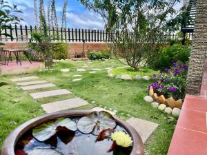 a garden with a pond in the middle of a yard at villa danisa hoa in Khu Chi Lăng