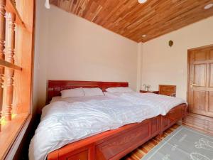 a bedroom with a large bed with a wooden headboard at villa danisa hoa in Khu Chi Lăng
