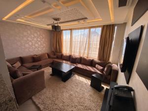 a living room with a couch and a table at Résidence La Place in Laayoune