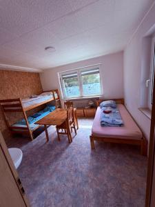 a bedroom with two bunk beds and a table at Gästehaus Nachtigall in Gädheim