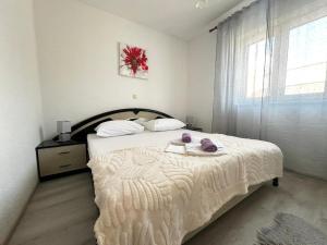 a bedroom with a white bed with a large window at Guest House Angela in Senj