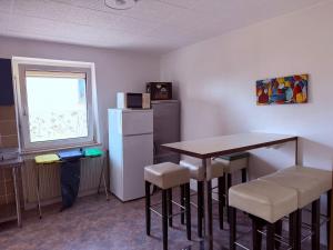 a kitchen with a table and chairs and a refrigerator at Gästehaus Nachtigall in Gädheim +7 photos