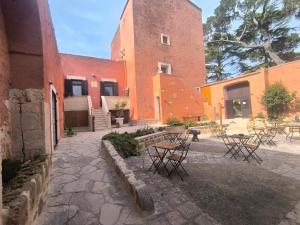 a group of tables and chairs in front of a building at Residenza Borgo Francescano in Gioia del Colle