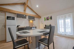 a kitchen and dining room with a table and chairs at les piafs du der 1 in Joncreuil