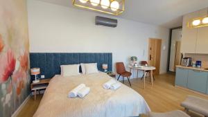 a bedroom with a large bed with towels on it at Boszkowo Horizon Park Apartament 14 "Laguna" in Boszkowo +15 photos