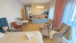 a kitchen and a living room with a table and chairs at Boszkowo Horizon Park Apartament 14 "Laguna" in Boszkowo