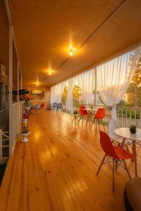 a room with a wooden floor with chairs and tables at TA-mari in Ureki