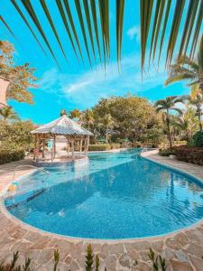 a swimming pool at a resort with a gazebo at Tropical Bliss Pool Wi-Fi BBQ Near Quepos Manuel Antonio in Quepos