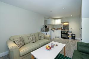 a living room with a couch and a table at Abbey View Coach House in Youghal +26 photos