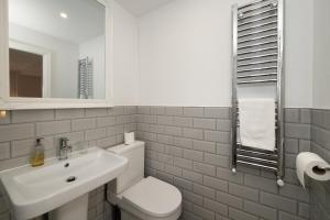 a bathroom with a white toilet and a sink at Abbey View Coach House in Youghal