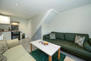 a living room with a green couch and a table at Abbey View Coach House in Youghal