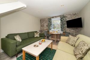 a living room with a green couch and a table at Abbey View Coach House in Youghal