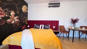 a bedroom with a yellow bed and a table and chairs at Boszkowo Horizon Park Apartament 15 "Bordowy" in Boszkowo