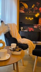 a living room with a table with a blanket on a couch at Boszkowo Horizon Park Apartament 15 "Bordowy" in Boszkowo
