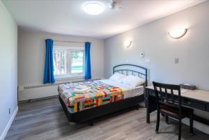 a bedroom with a bed and a desk and a table at Nekinan Lodge in Smoky Lake +35 photos