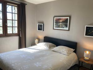 a bedroom with a bed with two pillows and a window at La Chêneraie Chambres d'hôtes-B&B in Payrac