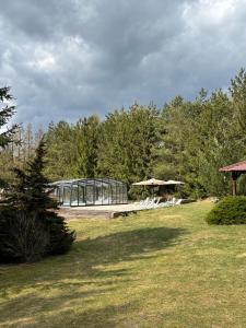 a glass building with a bench in a park at Port Jabłonka in Jabłonka