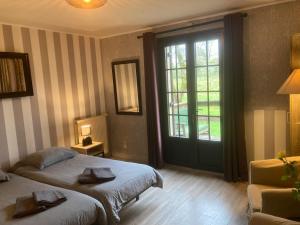 a bedroom with two beds and a large window at La Chêneraie Chambres d'hôtes-B&B in Payrac +41 photos