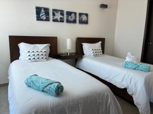two beds sitting next to each other in a room at La Poza Condominio in Isla Mujeres +18 photos