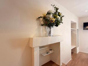 a vase of flowers sitting on a shelf in a room at Le Terrazze sul Fiume in Santa Sofia +34 photos