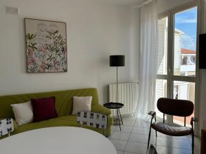 a living room with a green couch and a window at A & M Appartamento con garage in Livorno