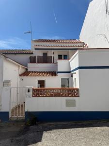 a white house with a blue and white fence at Casa da Ti'nês in Bombarral