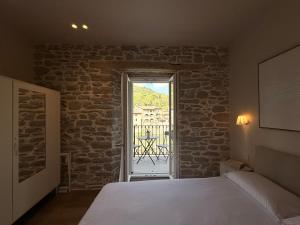 a bedroom with a bed and a door to a patio at Le Terrazze sul Fiume in Santa Sofia