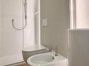 a white bathroom with a toilet and a sink at Le Terrazze sul Fiume in Santa Sofia