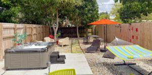 a backyard with a table and an umbrella and chairs at After Hours - Wilton Drive and Jacuzzi in Fort Lauderdale