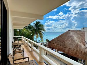 a balcony with chairs and a view of the ocean at Charly Beach Hotel in Isla Mujeres
