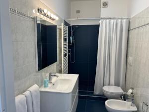 a bathroom with a sink and a toilet and a shower at A & M Appartamento con garage in Livorno +8 photos